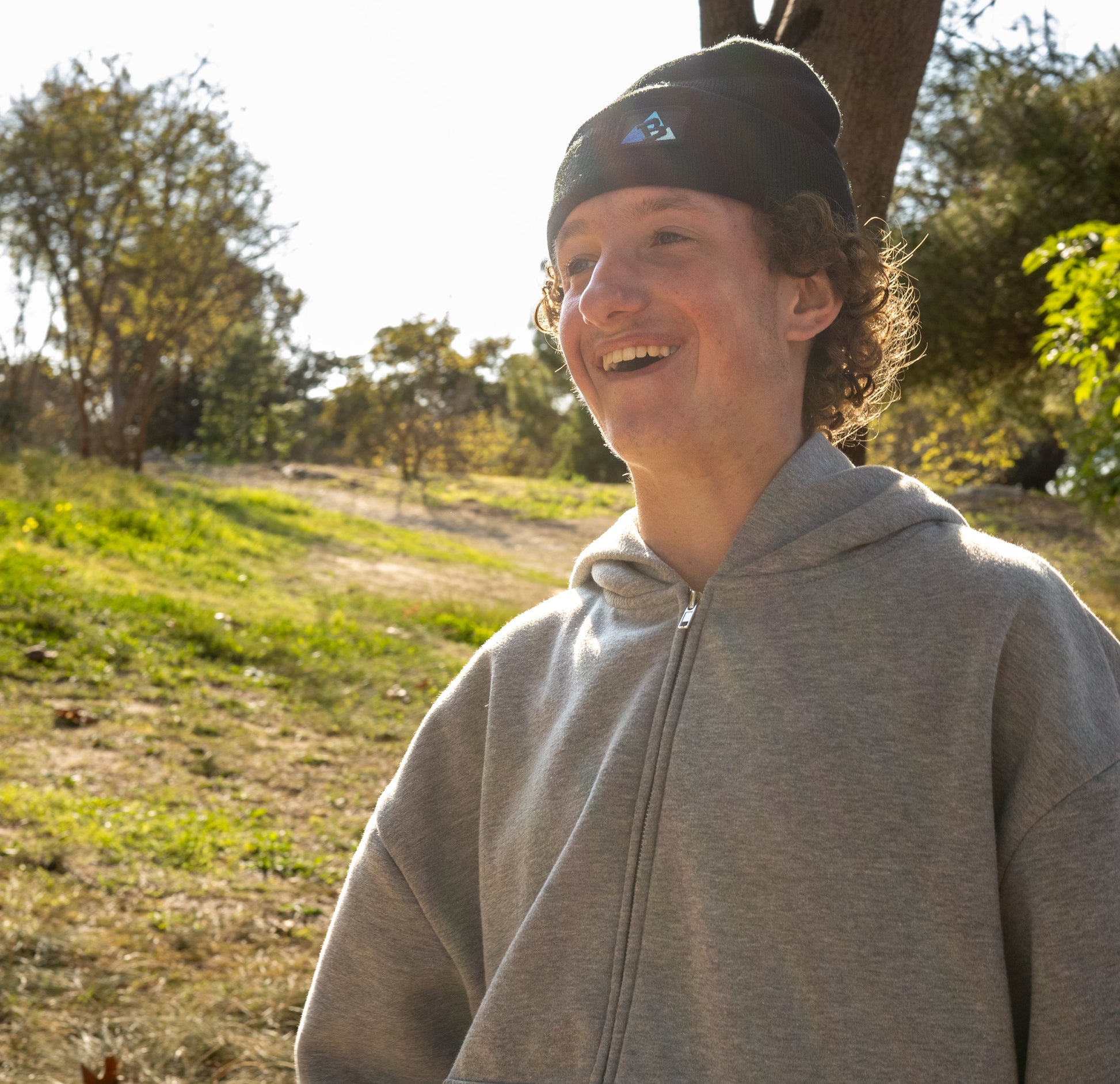 A person wearing a Buckland beanie in the park on a sunny day